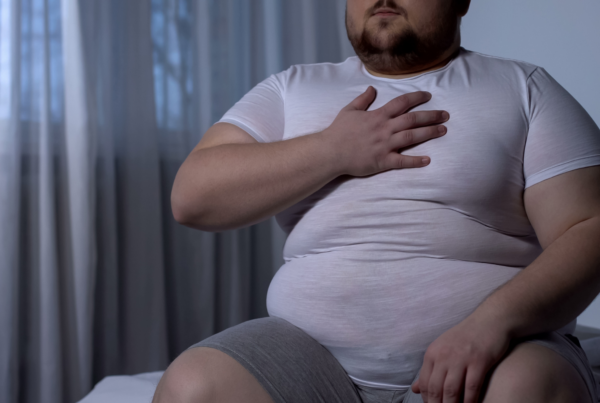 A man sits on his bed at night, distraught after receiving a metabolic syndrome diagnosis.