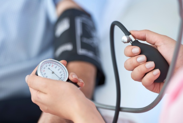 A patient asks his nurse, “What is considered high blood pressure,” as she measures his using a sphygmomanometer.