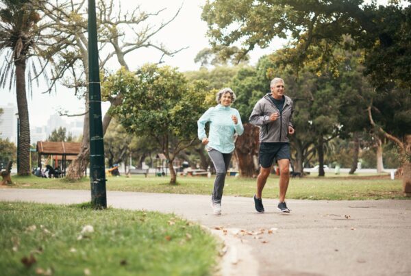 Active elderly man and woman running outdoors.