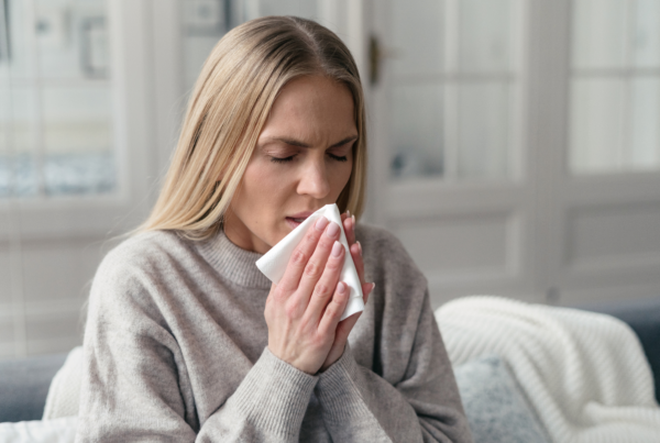 Woman coughing with upper respiratory infection or allergies.