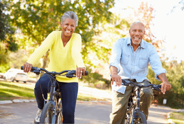 Active senior couple enjoying bicycle ride in park.