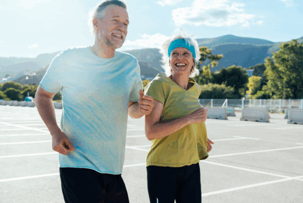 Smiling man and woman running outdoors in nature.