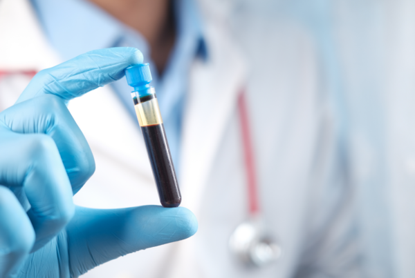Medical professional holding blood test tube.